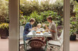 © Westend61 - Two happy mothers at breakfast table outdoors with their child
