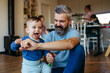 © Halfpoint - Father playing with little son on floor.