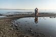 © ADDICTIVE STOCK - Couple on rocky beach at sunset with reflection