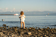© ADDICTIVE STOCK - Child playing on a pebbly beach at sunset