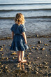 © ADDICTIVE STOCK - Child gazing at serene beach waves in evening light