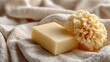 © Strother - Natural handmade soap bar and soft sponge resting on a beige textured towel for spa wellness and skincare hygiene concepts featuring organic bath products for relaxation