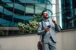 © Zamrznuti tonovi - Businessman walking in city listening to music pointing up