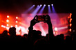 © 9parusnikov - Person recording live concert performance with horizontal smartphone