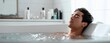 © Marta B - The man in a bathtub enjoying a peaceful luxury bath at home