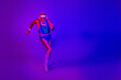 © deagreez - Elderly man in retro blue purple jumpsuit runs in neon studio lights conveying fitness energy and vintage style
