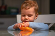 © zwiebackesser - Childhood curiosity and independence during snack time.