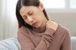 © Pormezz - muscles stiff problem, suffer young woman, girl face painful, hand holding neck ache from work hand holding massaging rubbing shoulder hurt, sore sitting on couch at home