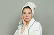 © artmim - Attractive woman taking care of her skin wearing sheet mask. Skin care and hydration concept