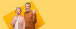 © Prostock-studio - Two senior adults express happiness together in a colorful background. They share smiles and gestures that show engagement and friendship. Their poses reflect positivity and warmth.