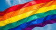 © Royal Ability - Vibrant rainbow pride flag close up waving diagonally against blue sky silky fabric texture bright colors political symbol of lgbtq rights celebration bold sunlit movement large