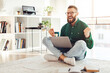 © Prostock-studio - Emotional Freelancer Man Shouting Using Laptop Computer Celebrating Business Success Sitting On Floor At Home. Joyful Bearded Guy Shaking Fists In Joy Working Online. Successful Entrepreneurship