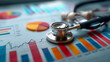 © Daria - Medical stethoscope resting on colorful financial charts and graphs representing healthcare data analysis and medical research insights