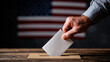 © Enrique - Close up of hand inserting ballot into voting box with American flag