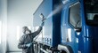 © Tanrarte - Professional truck painter in protective gear spraying blue truck in modern workshop