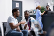 © DC Studio - Focused conversation unfolds as doctor reviews xray scan with black male patient during clinic visit. Physician explains findings clearly, assisting man with next steps and treatment options.