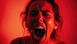 © miss irine - Woman screams in intense red light, showing raw emotion, fear, or pain. Close up portrait captures loud vocalization, distress, or anger in dramatic lighting.