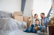 © Serhii - Family celebrating moving into new home with boxes