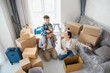 © Serhii - Family moving to new home unpacking cardboard boxes