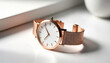© miss irine - Rose gold minimalist watch with white dial and mesh band sits on white table. Elegant accessory shows simple design and luxury style, perfect for fashion.
