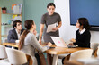 © JackF - Young woman discusses the project with a team of colleagues at a table. Business meeting and collaboration in a modern office