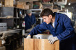 © JackF - Young worker assembles a wooden table in a furniture factory. Work process
