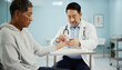 © Joz - Doctor Examining Senior Patient’s Hand in Medical Clinic