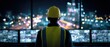 © SKV - The Operator in High Visibility Vest Overlooks Night City from Industrial Control Room Windows