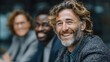 © Prostock‑studio - Smiling confident man with curly hair and beard leading diverse business team in modern office setting promoting collaboration and a positive mood