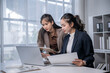 © Apichat - Businesswomen collaborating on laptop during office meeting