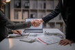 © Apichat - Business people shaking hands confirming agreement in office