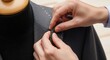 © Nataly - Hands performing suit tailoring on gray jacket, showing detailed stitching. Professional suit tailoring process by artisan, ensuring custom fit and quality.