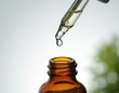 © miss irine - Clear liquid drips from dropper into amber bottle. Precision dosing for serum, oil, or medicine. Close-up focus on pharmaceutical or cosmetic formulation.
