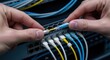 © Nataly - Hands establishing network connection by plugging fiber optic cable into server switch. Network connection involves data transfer technology and information flow within communication system.