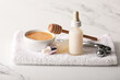 © Pixel-Shot - Spa composition with towel, facial massage tool and bottles of cosmetic products on marble background, closeup