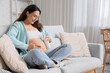 © Pixel-Shot - Young pregnant woman applying body lotion at home
