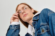 © Bliss - Young man with long red hair showcases stylish denim in modern studio setting
