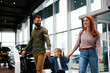 © djile - Young family walking through car dealership showroom