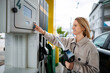 © Jelena - Woman buying gasoline at self-service filling station