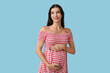 © Pixel-Shot - Happy pregnant woman on blue background