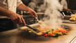 © Jim - Chef cooks shrimp and vegetables on a hot teppanyaki grill. Steam rises as food sizzles on the flat iron griddle. Preparation of Japanese cuisine involves fresh ingredients. Teppanyaki & Japanese