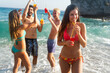 © NDABCREATIVITY - Happy youth on summer break having fun on the beach, laughing in the waves, enjoying sunshine