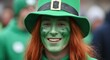 © MdRasel - Person with green face paint and a leprechaun hat smiling at a public event, st. patrick's day
