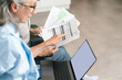 © brizmaker - Senior couple reviewing bills and financial documents at home on a laptop