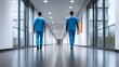 © Nataliia_Trushchenko - Two nurses walk down a hallway in a hospital. The hallway is empty and the nurses are wearing blue scrubs