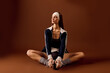 © LIGHTFIELD STUDIOS - Stylish young woman in sportswear showcases athletic grace in brown studio