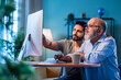 © StockImageFactory - Indian young son helping senior father learn desktop computer at home