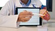 © DawDunia - Doctor explaining heart condition or anatomy using a human heart model, pointing to coronary arteries while showing an ecg on a digital tablet screen, delivering medical education