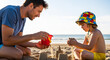 © Andrey - Father and child building sandcastle together on beach in summer