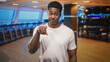 © Krakenimages.com - Man points finger at camera in studio gym among treadmills and a weight rack while wearing a white tshirt; challenge accountability.